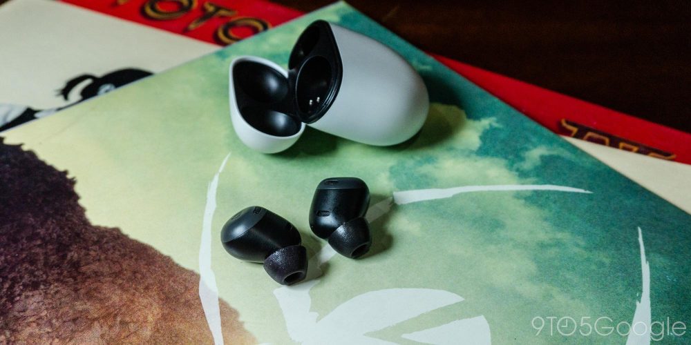 Pixel Buds Pro with Comply foam tips, sitting on a stack of vinyl records